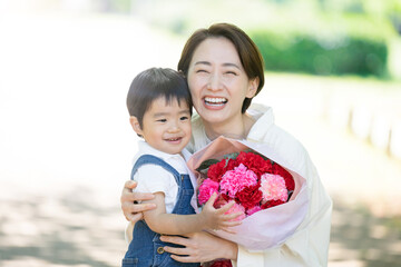 花束を母親に贈る息子　母の日や誕生日記念日に　カメラ目線	
