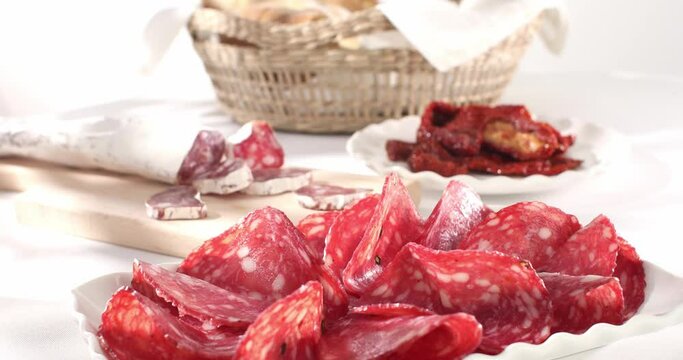 slices sausage salchichon on a plate. salami on a cutting board. cold cuts with bread and tomatoes. traditional spanish and italian sausages. meat delicacies antipasto on the table. Generative AI