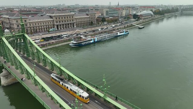 Aerial view of Budapest Szabadsag hid (Liberty Bridge or Freedom Bridge), connects Buda and Pest across the River Danube. A tram circulates within historic city along iconic bridge