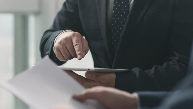 two asian business men shaking hands in office after reaching an agreement