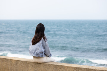 Woman sit beside the waterfront in Taiwan