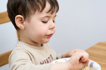 young boy eating oatmeal for breakfast