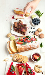 Table with various cookies, cakes and fruits. Delicious dessert table.