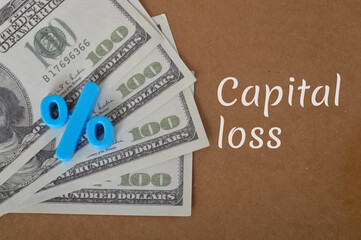 Money banknotes and percentage symbol with text CAPITAL LOSS.