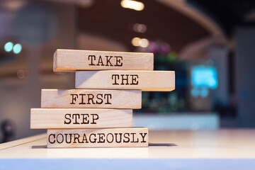 Wooden blocks with words 'Take the first step courageously'.
