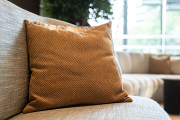 A brown pillow on armchair or sofa in contemporary style. Interior decoration and furniture object photo.	
