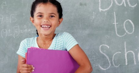 Animation of mathematical equations over biracial girl holding files smiling in the class at school - Powered by Adobe