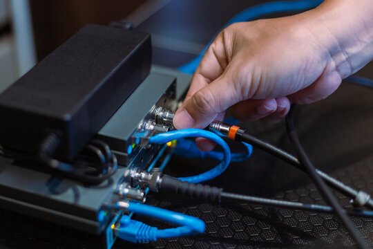Male hand working, connecting cable SDI and HDMI to Wireless Video Transmitter and receiver system. Television studio live broadcast. media set production.