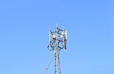 Silhouette of cellular antennas in the blue sky background at Thailand.