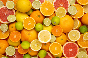 Concept for fresh, fruity and juicy fruit. Top view. Delicious fruit background made of many different colorful fresh cut, halved and whole citrus fruits