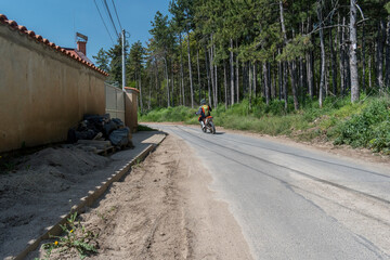 A person driving a motorcycle on an asphalt road.