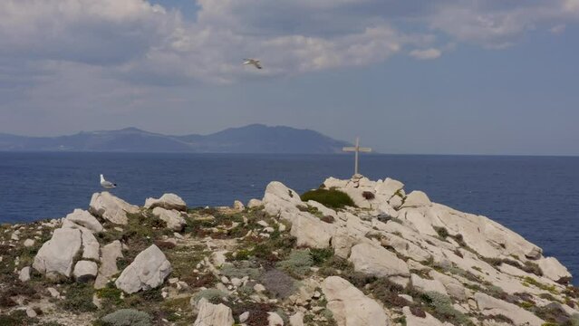 Seagulls on an uninhabited island in Greece - Orthodox cross in the background