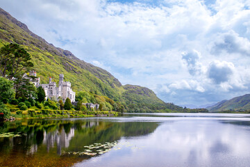Fototapeta na wymiar Kylemore Abbey with water reflections in Connemara, County Galway, Ireland, Europe. Benedictine monastery founded 1920 on the grounds of Kylemore Castle. Mainistir na Coille Moire