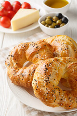 Turkish Bread Rings Acma served with tomato, cheese, olive and olive oil closeup on the plate on the table. Vertical