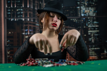 attractive girl in a black dress is leaning on the table, holding a poker chip and looking away. poker. casino