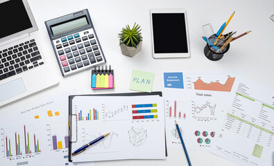 Business office desk with graph or annual report with laptop, pen calculator