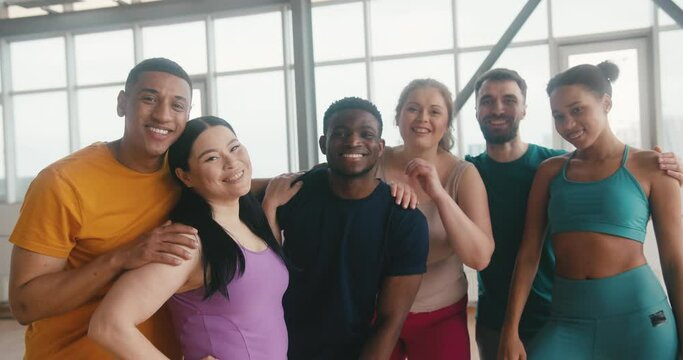 Hugging people enjoy going to yoga class together in gym