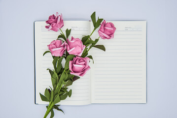 Fototapeta premium Roses and notebook on white background