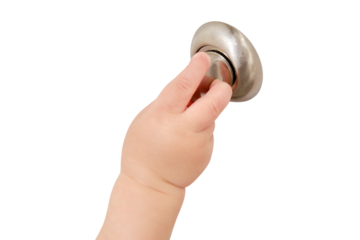 Toddler baby opens the lock, child hand close-up, isolated on a white background. White wooden door, metal door handle and baby hand