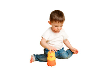 Toddler baby is playing logical educational games with a sandbox mold on a studio isolated on a...