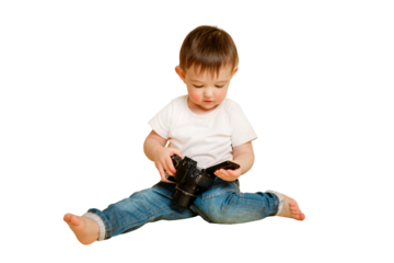 Toddler baby photographer with a camera on a studio isolated on a white background. Happy child with photo equipment in a white t-shirt and blue jeans. Kid aged one year and four months