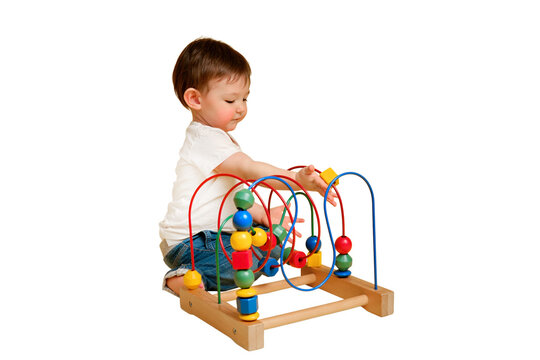Toddler baby is playing logic educational games on a studio isolated on a white background. Happy child play with educational toy, learning logic, copy space. Kid aged one year and four months