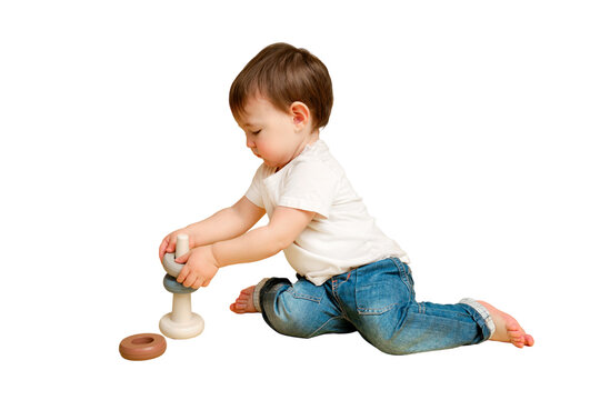 Toddler baby is playing logic educational games with a pyramid on a studio isolated on a white background. Happy child playing with a pyramid educational toy. Kid aged one year four months