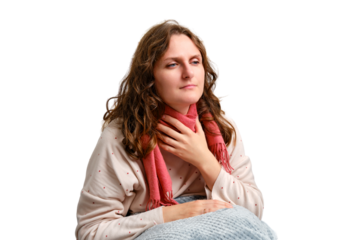 A sick woman holding a sore throat with a red scarf, neck pain, isolated on a white background. Adult ill woman sitting on a home bed in a white bedroom, female aged 35 years