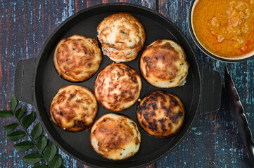 Indian breakfast kuzhi paniyaram in a frying pan.