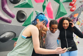 Fototapeta premium Group Of Multi-Cultural Friends Looking At For Selfie By Climbing Wall At Indoor Activity Centre