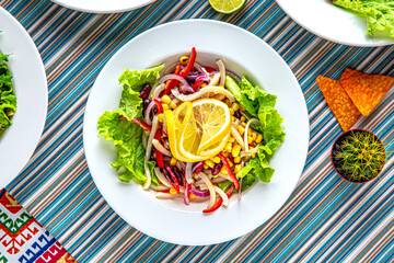 Traditional mexican food. Salad of squid corn, bell peppers and beans. Colorful Food Table Celebration Delicious Party Meal Concept. 