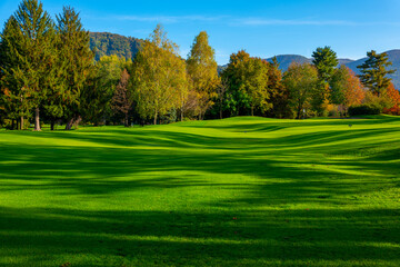 Golf Course with Shadow and Sunlight and Autumn Trees in a Sunny Day in Lugano, Ticino, Switzerland.