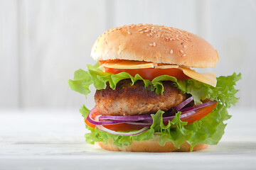 Meat cutlet burger with tomatoes, cheese, onions on the table