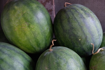 whole watermelons on a fruit stand shelf. Citrullus lanatus 