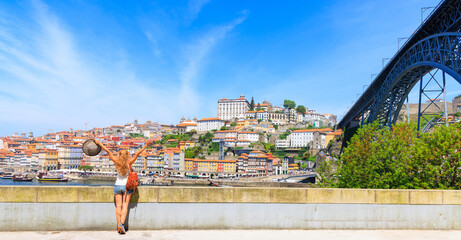 Naklejka premium Panorama view of Porto cityscape, old town and dom luis bridge with woman traveler- Portugal