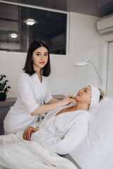 Obraz premium The doctor cosmetologist makes Lip augmentation procedure of a beautiful woman in a beauty salon. Prp therapy, anti wrinkle and aging skin. Cosmetology skin care