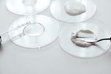Cosmetics Samples in Laboratory Glassware on white background, consistency test of gel and cream