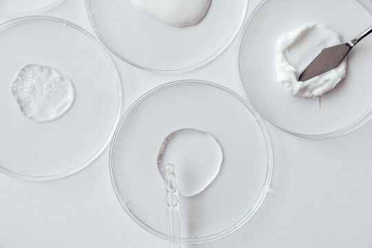 Cosmetics Samples in Laboratory Glassware on white background, consistency test of gel and cream