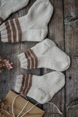 Fototapeta na wymiar Brown baby socks made of soft cotton yarn, o dark wooden background