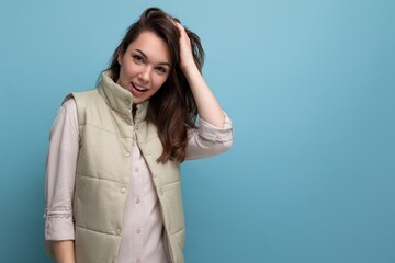 portrait of charming dreamy woman with dark hair posing on blue background with copy space