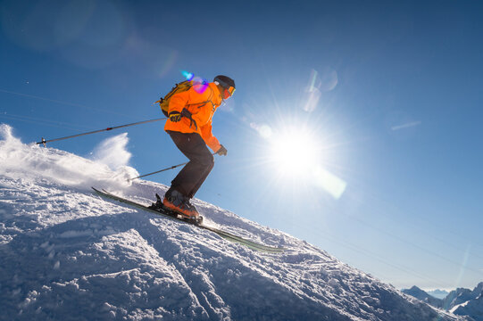 good skiing in snowy mountains. a nice winter day, an incredible ski drive from which a skier jumps against the backdrop of a snowy sunny day