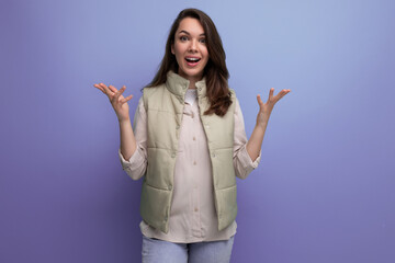 caucasian young brunette woman with hair below her shoulders smiles and poses against the background with copy space