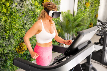Woman wearing virtual reality headset and running on treadmill in a gym