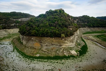 Fotobehang Sau, Spain - 28 April 2023: The Ter river is seen before the Sau reservoir as the drought caused by climate change causes water shortages in Spain and Europe. © davide bonaldo