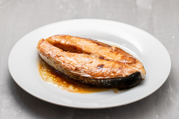 Fried salmon steak with sauce on white dish