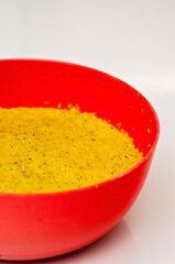 Yellow falafel dough in a red plastic bowl ready to be made into balls and fried. Falafels are Middle Eastern food made from chickpeas or broad beans. Homemade street food.