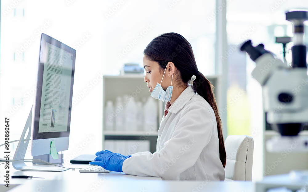Poster Doing some more research online. a young scientist working on a computer in a lab.