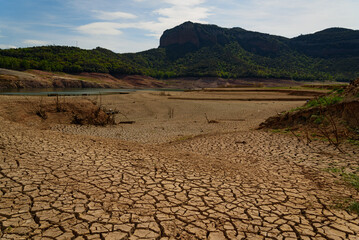 Scorched earth and earth clods are seen on dry land caused by drought and lack of rain due to climate change. Concept of water shortage and climate crisis, cracked earth and dry soil.