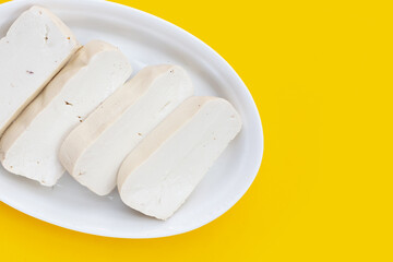 White tofu in yellow plate on yellow background