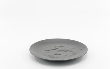 immagine con piatto in materiale gress grigio con chiazze di acqua su superficie bianca